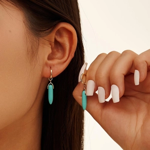 S925 sterling silver turquoise bullet drop earrings in gold finish on a female model