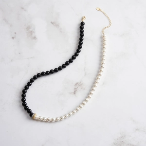 Détail du collier épissé en obsidienne et perles avec pendentif cercle doré en zircon