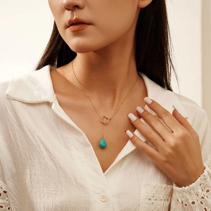 925 silver gold clover necklace featuring teardrop turquoise pendant on white shirt