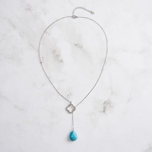 Detail of 925 silver Y-necklace with turquoise teardrop pendant and clover charm