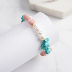 Detailed macro shot of natural stone bracelet with pink, turquoise, and pearl beads