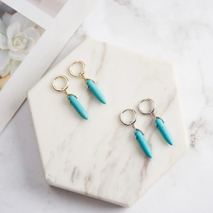 Detailed macro view of S925 silver and gold hoop earrings with turquoise cone pendants