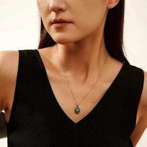 Vintage S925 silver necklace with turquoise pendant on a model wearing black V-neck top