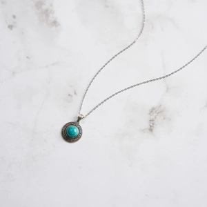 Macro detail of S925 sterling silver stamp and turquoise pendant on vintage chain