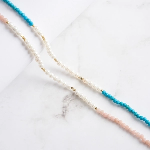 Macro detail of S925 silver necklace with pink opal, blue faceted beads, and white pearls