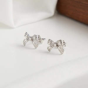Detailed view of silver ribbon bow stud earrings made of S925 sterling silver material