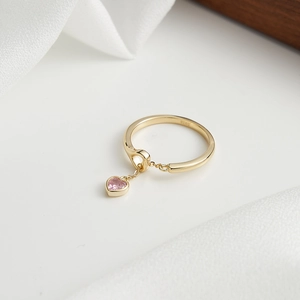Detailed macro of S925 sterling silver ring with a dangling pink heart zircon charm