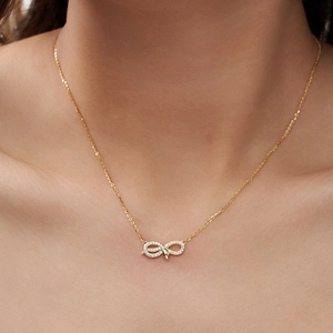 Gros plan d'un collier en argent S925 doré avec pendentif infini serti de zircons