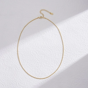 Close-up of golden Chopin chain necklace with lobster clasp and adjustable extension link