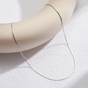 Detail of elegant S925 sterling silver bamboo link chain on a minimalist display