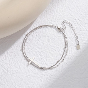 Macro detail of S925 sterling silver stamp on a layered cross pendant bracelet