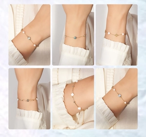 Detailed close-up of six gold charm bracelets with pearls and mother-of-pearl clovers