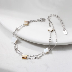 Detail of silver S925 chain bracelet with double layer and shell clover charms