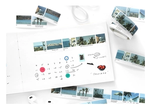 Détail de ruban washi avec paysages de plage et citations sur un carnet blanc