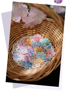 Macro detail of watercolor dream galaxy crystal and flower stickers in a lace basket