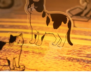 Close-up of cute black and white cat illustration on a clear acrylic decorative stand