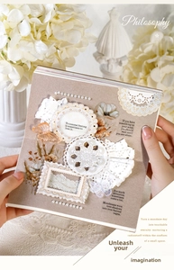 Macro view of vintage lace stickers and decorative pearls on a craft scrapbook page