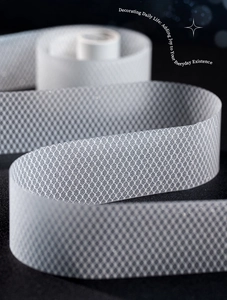 Macro view of white diamond grid ribbon with sparkling glitter on dark background