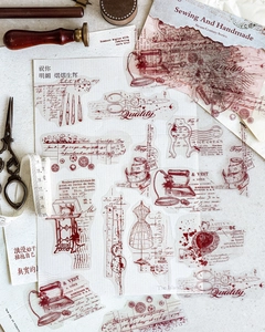 Detailed view of vintage sewing theme stickers featuring red line art on craft paper