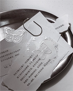 Macro shot of silver PET butterfly stickers with celestial motifs on vintage paper