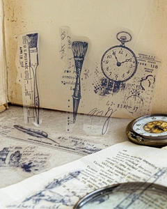 Macro shot of blue vintage PET stickers featuring retro ink pens and pocket watch designs