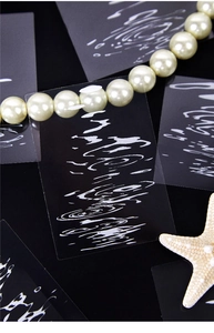 Detail of PET stickers with white water ripple patterns on deep black background