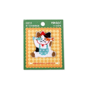Cute calico cat embroidery patch with red hat holding a fish on display card