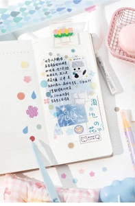 Flat lay of geometric PET tape stickers, grid notebook, and macaron colored stationery set