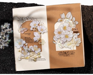 Detail of gold-foiled flower and butterfly PET stickers applied to a vintage journal page