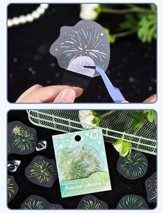 Macro view of semi-transparent fireworks stickers being peeled with tweezers for journaling