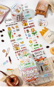 Close-up of decorative scrapbooking tape with cute hand-drawn cat and dessert illustrations