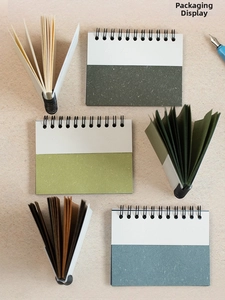 Detail view of multi-color specialty paper coil notebooks with textured covers and metal binding
