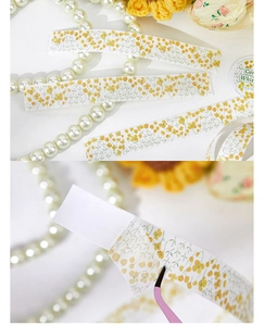 Macro detail of yellow floral washi tape with tweezers showing the backing and adhesive
