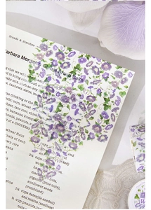 Detailed view of purple morning glory floral stickers on vintage French recipe paper