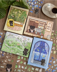 Detail of cute black cat themed PET stickers showing cozy cafe and home DIY puzzle scenes