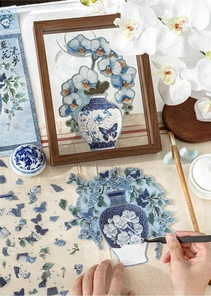 Macro detail of blue floral PET stickers showing numbered guides for vintage vase collage art