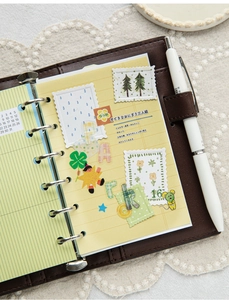 Detail of a vintage dark brown leather binder with aesthetic stickers on lace fabric