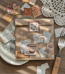 Detail of vintage embossed stamp stickers with coffee and cat motifs on a paper envelope