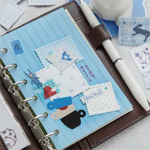 Brown leather binder notebook featuring colorful stamp-style stickers and collage materials