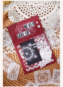 Close-up of vintage scrapbook kit featuring floral PET stickers and lace materials