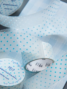 Macro detail of gradient blue polka dot masking tape with fine glitter texture