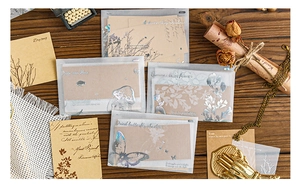 Detailed view of vintage scrapbook material pack with vellum envelopes and kraft paper stickers