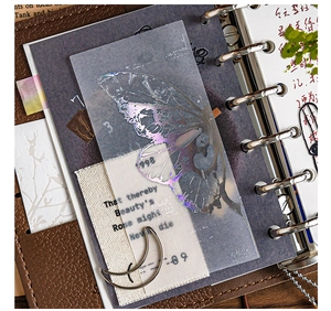 Macro detail of holographic butterfly wing films on a vintage journal for DIY scrapbooking