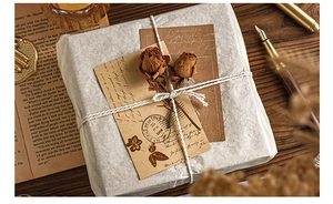 Detail of vintage scrapbooking paper set with dried roses and rustic twine on dark wood