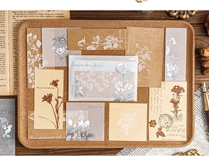 Close-up of vintage floral scrapbooking papers with silver stamping and artistic script