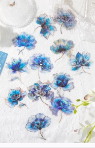 Close-up of translucent blue PET floral stickers with iridescent laser finish for journaling