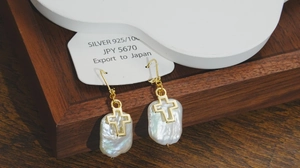 Détail des boucles d'oreilles croix en perles baroques et argent S925 sur carte
