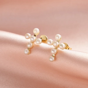 S925 sterling silver cross earrings with natural white pearls on pink silk fabric
