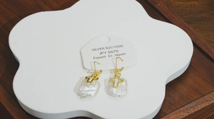 Détail des boucles d'oreilles perles baroques avec croix dorées sur monture argent 925
