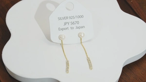 Detailed view of S925 silver pearl drop earrings with gold chains and crystal bars